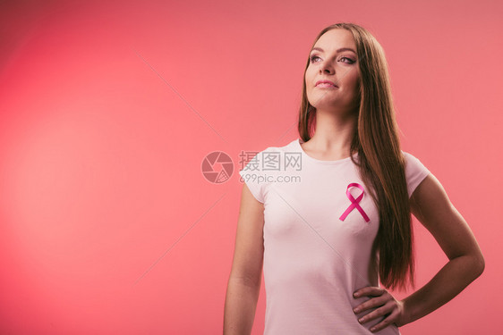 乳房上的粉色妇女癌症丝带保健医药和乳腺癌认识概念工作室拍摄红色背景胸口上的粉色妇女癌症丝带胸口上的粉色妇女癌症丝带图片