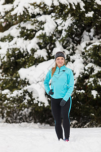 穿着运动服背景树木的女孩冬季运动户外健身康概念穿着冬季运动服的常住女孩树木背景图片