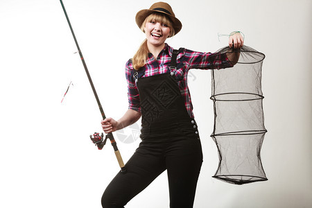 戴着太阳帽的快乐女人拿着钓鱼棒和保持网的乐趣图片