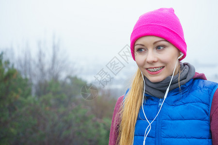 参加户外体育锻炼运动装饰思想参加温暖运动服装训练的妇女秋季在户外锻炼和听音乐参加运动服装锻炼的妇女秋季在户外锻炼参加运动的妇女秋图片