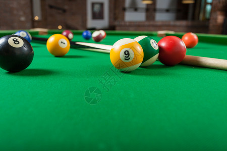 Billiard球和杆粘在绿色桌上池球游戏史努克和坚持在台桌上背景图片