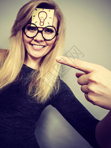 穿着怪的书呆子眼镜前额有灯泡标记好主意或解决办法的妇女前额有灯泡标记的妇女图片