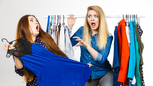 两个有趣的女人在购物时互相争吵关于一件衣服销售疯狂妇女在购物时争吵图片