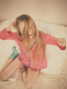 睡着后穿粉红色睡衣的年轻金发女青年睡着后穿粉红色睡衣身体伸展图片