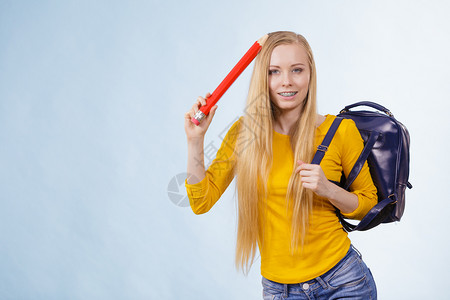 带着背包和拿大铅笔去上学或大的金发少女快乐的年轻金发女孩图片