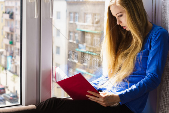 年轻女孩坐在飘窗上阅读看书图片