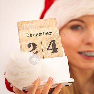 穿着圣诞老人礼帽的快乐年轻少女持有12月4日的历图片