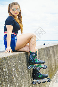 身穿溜冰鞋的年轻女子乘飞机后放松女在夏季海滨玩得开心图片