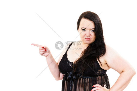 身穿黑蕾丝内衣小圆环的肥胖妇女加上身穿黑色内衣带的身长在复制空间用手指着超重的大胖子模型显示产品在白色上女加内衣尺寸指着复制空间图片