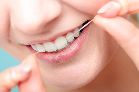 口腔卫生和保健微笑的妇女使用牙科线白健康齿用线微笑的妇女图片