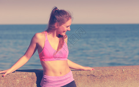 女在户外运动后休息在海边运动服上穿的适合身体女孩休息图片