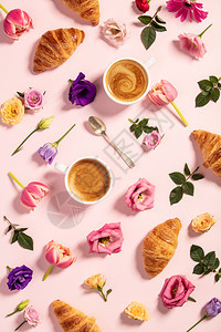 早上咖啡羊角面包和美丽的花朵模式粉红色背景的舒适早餐博客杂志网络设计师社交媒体和艺术家的平面布置图片