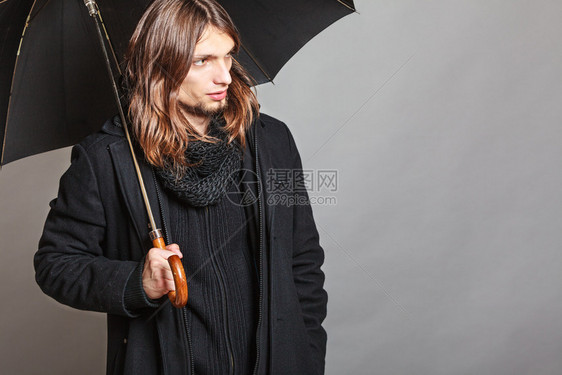 穿着黑色大衣和围巾的英俊时尚男子肖像年轻男子在工作室冬季或秋天时装上出现图片
