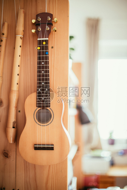 Ukulele和长笛挂在木书架上图片