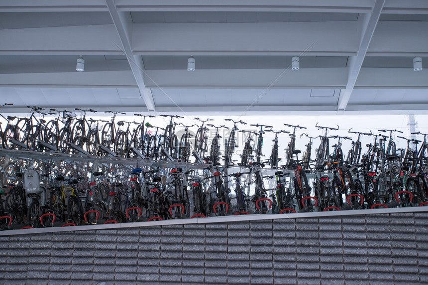 许多停在火车站站台架上的自行车图片
