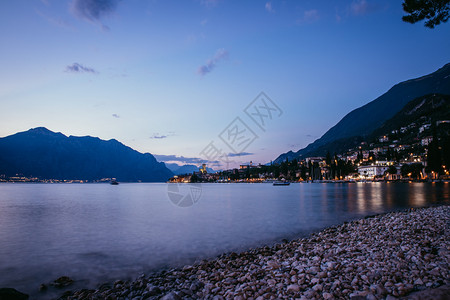 海滩上美丽的夜晚景色与可爱的小村庄意大利拉戈迪加达图片