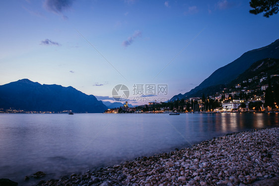 海滩上美丽的夜晚景色与可爱的小村庄意大利拉戈迪加达图片