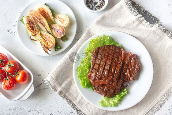 马铃薯和肉盘上的炸土豆和生鲜牛排图片