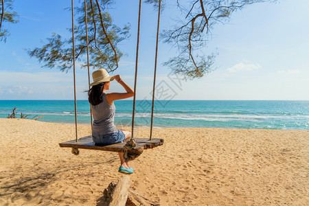 快乐的亚洲女在泰国普吉中午的海洋或自然户外度假旅行中在海滩上摇晃图片