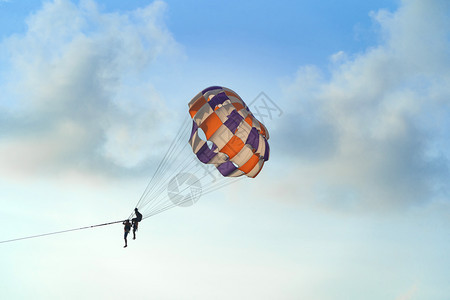人们乘坐多彩的降落伞或飞行同时乘坐蓝色的天空和云彩自由观旅行图片