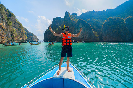 一名亚洲男子位游客站在艘船上泰国安达曼海的Krabi图片