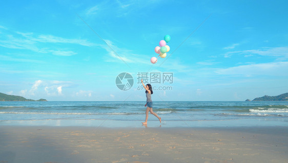 快乐的亚洲情侣在泰国普吉Phucket中午的海洋或自然度假室外旅行时在海滩上持有彩色气球图片