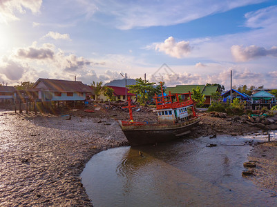 在泰国普吉市海岸一艘旧船沉没或废弃的渔船在日落天空下有瀑布图片