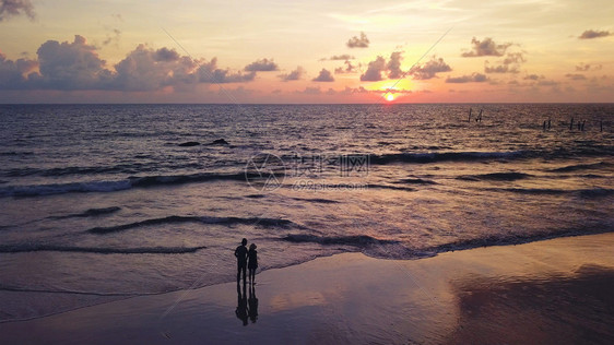 快乐的情侣在黄昏的海滩上度蜜月图片