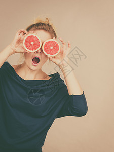 健康饮食新鲜品充满维他命女人拿着甜的柑橘水果葡萄两半假装是眼镜女人拿着水果葡萄半眼睛图片