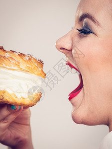 甜美的食物和快乐概念有趣是快乐金发女人拿着美味的巧克力蛋糕奶油吃