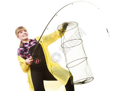 骑着黄雨衣的快乐女人拿着鱼棒保持网的乐趣图片