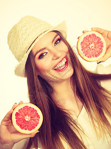 女有吸引力的长头发女多彩的双眼化妆将两半的葡萄果柑橘水握在手中健康饮食暑假欢乐概念过滤照片女将两半的葡萄果柑橘水握在手中图片