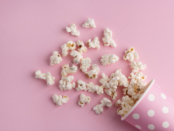 粉红背景的爆米花电影和娱乐概念图片