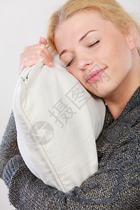 睡梦时间温暖的床铺疲倦概念快乐困苦疲累妇女微笑并抱着舒适的白色枕头快乐的困苦妇女拿着舒适的枕头图片