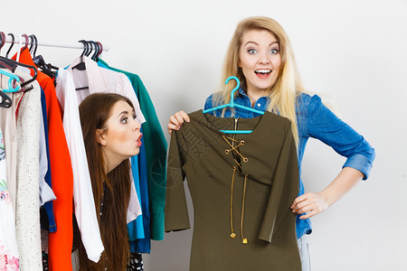2名女青年在购物时为朋友挑拣完美的临时短裙高清图片