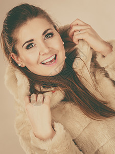 穿着轻的毛皮温暖舒适大衣的有魅力女子穿着适合冬天的衣帽寒冷时装概念穿着毛衣的有魅力女子图片
