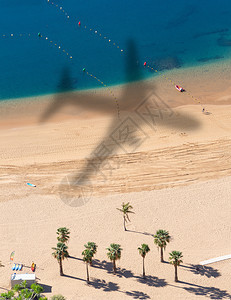 在沙滩上有飞机飞行的影子图片
