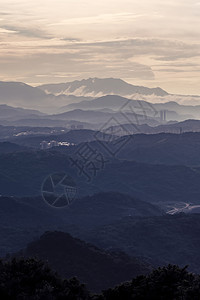 新北市日落时森林树木和山脉带可见的环影有雾和云空自然景观图片