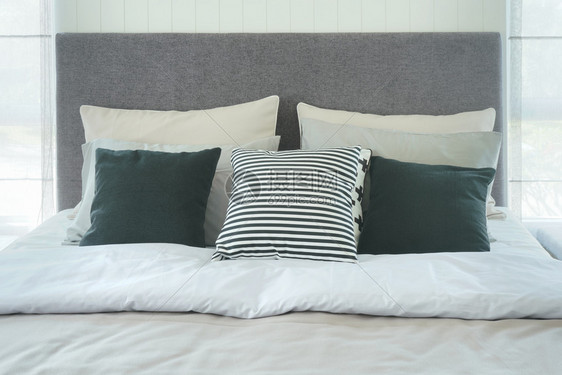 在现代式室内卧里用枕头和紧贴床铺图片
