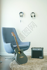 配有灰色手椅吉他和耳机的音乐工作室图片
