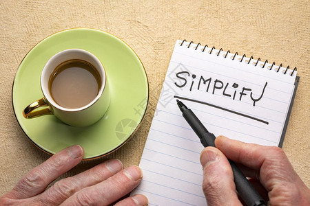 简化单词男人用手写纸条黑标记写在螺旋笔本上用咖啡杯图片