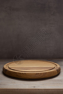 在前木板背景的生锈制桌子上切比萨饼板图片