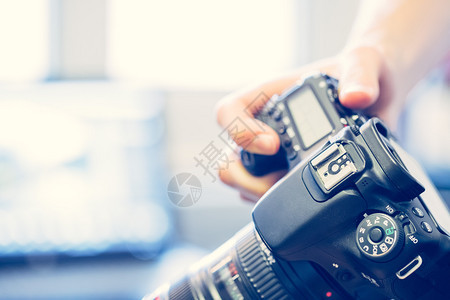 摄影师手上有一台反射照相机手持远光镜头图片