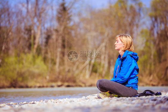 女人坐在石子沙滩上冥想图片
