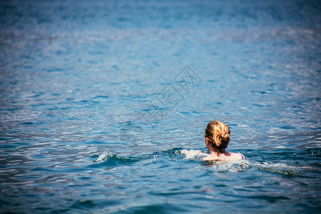节假日运动妇女正在蓝水中游泳图片