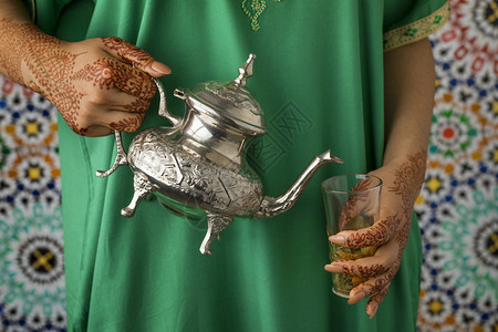 摩洛哥妇女用传统染红花粉的手浇茶图片