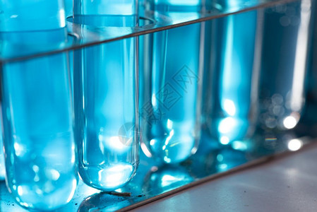 研究人员在实验室化妆品和能源研究中使用玻璃器械和蓝色溶液图片