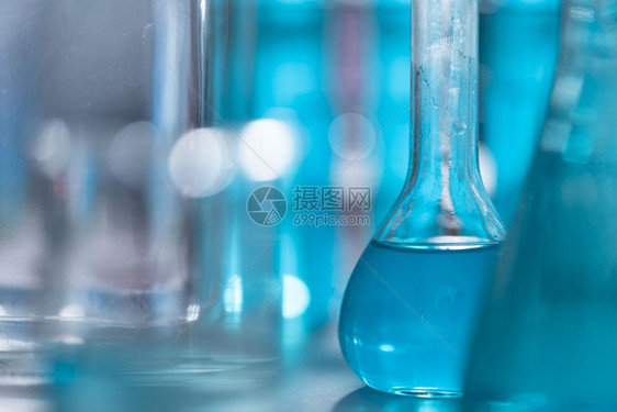 研究人员在实验室化妆品和能源研究中使用玻璃器械和蓝色溶液图片
