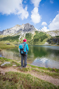 背着包的金色女登山者正在享受风景图片