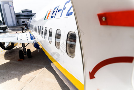 蓝色入口图在乘客下机时停放的一架飞机打开门背景